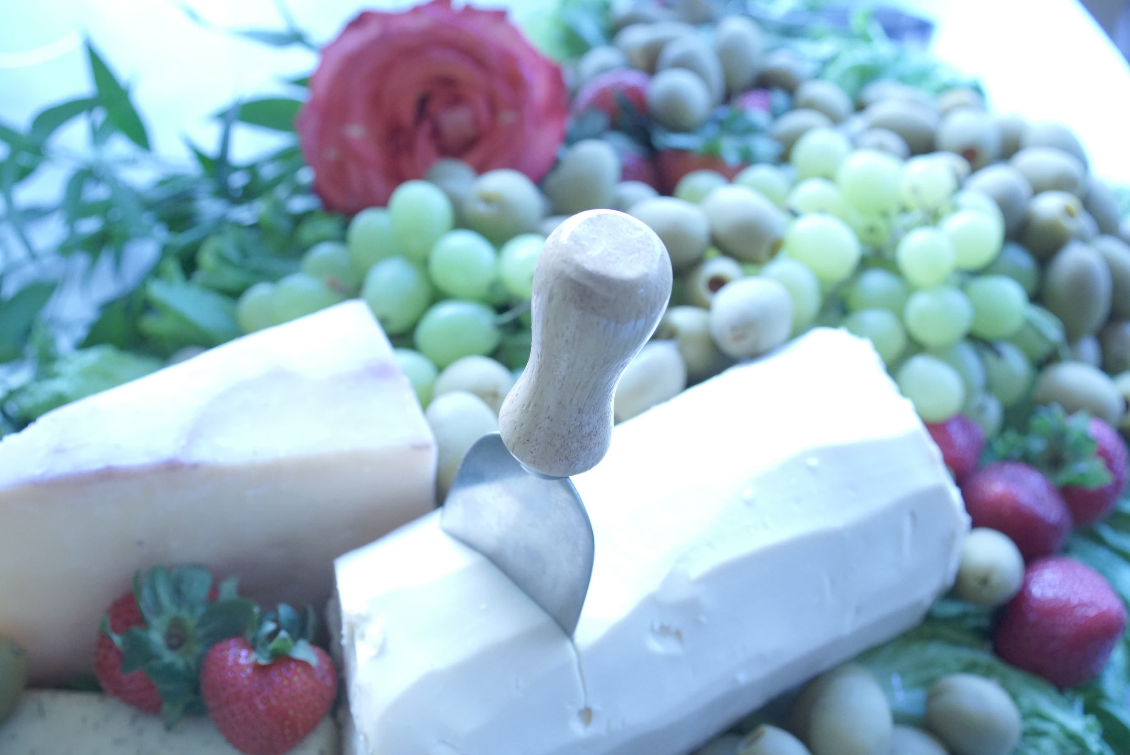 Catering spread with cheese, fruit, and florals
